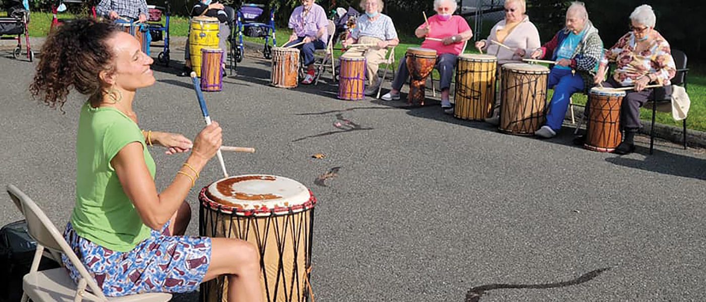 Residents at the Arbors in Chicopee participate in an outdoor drumming circle.