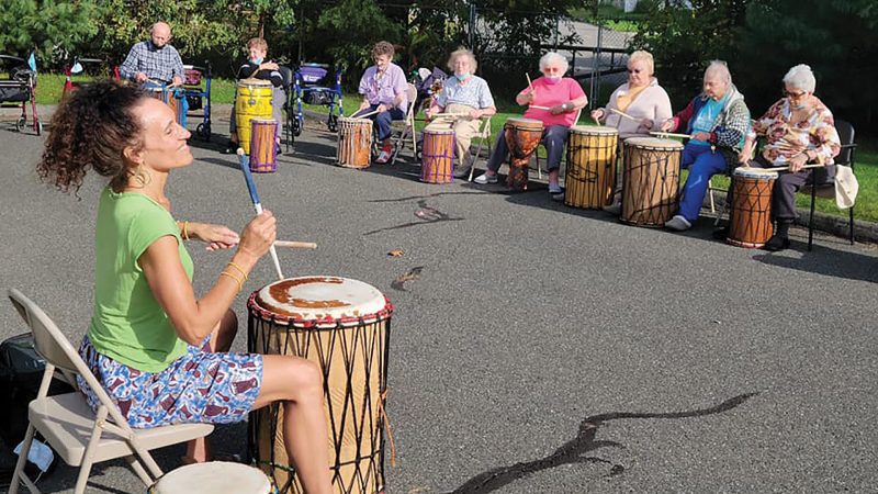 Residents at the Arbors in Chicopee participate in an outdoor drumming circle.